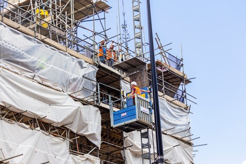 Newcastle Upon Tyne – men working on scaffolding, using a lift and ladders to access the top